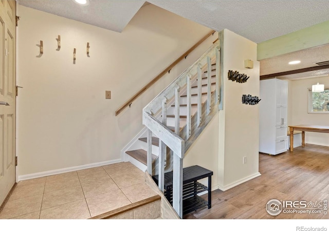 985 W 10th St Unit A5, Loveland, CO 80537 - stairway featuring a textured ceiling, baseboards, recessed lighting, and wood finished floors
