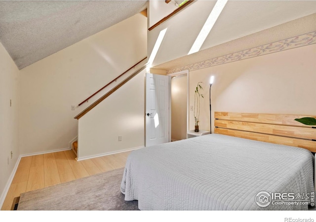 985 W 10th St Unit A5, Loveland, CO 80537 - bedroom featuring lofted ceiling, wood finished floors, and baseboards