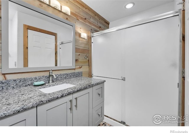1309 Red Mountain Dr, Longmont, CO 80504 - bathroom featuring vanity, a shower stall, and wood walls