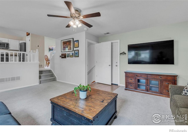 1309 Red Mountain Dr, Longmont, CO 80504 - carpeted living room featuring a ceiling fan and stairway