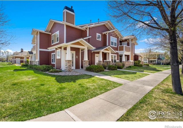2202 Owens Ave # 102, Fort Collins, CO 80528 - view of front of property featuring a chimney, a front lawn, and stone siding