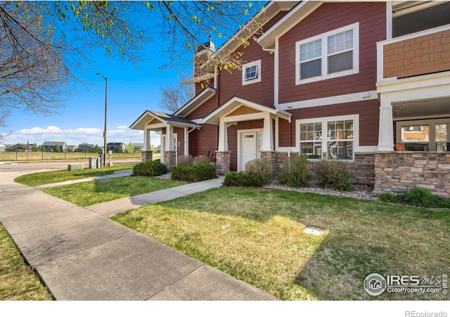 2202 Owens Ave # 102, Fort Collins, CO 80528 - craftsman-style home with a front yard, a chimney, and stone siding