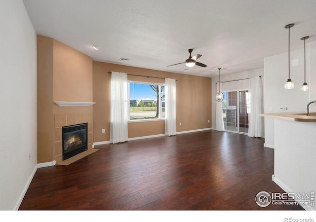 2202 Owens Ave # 102, Fort Collins, CO 80528 - unfurnished living room with ceiling fan, a tile fireplace, healthy amount of natural light, and wood finished floors