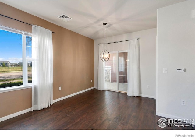 2202 Owens Ave # 102, Fort Collins, CO 80528 - spare room featuring a chandelier, dark wood finished floors, and baseboards