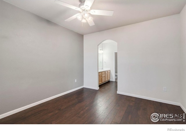 2202 Owens Ave # 102, Fort Collins, CO 80528 - unfurnished room with arched walkways, dark wood-style floors, baseboards, and a ceiling fan