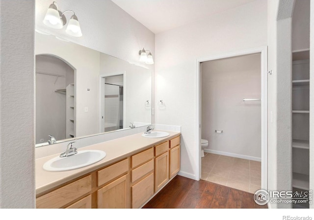 2202 Owens Ave # 102, Fort Collins, CO 80528 - full bath with a walk in closet, double vanity, toilet, wood finished floors, and a shower with door