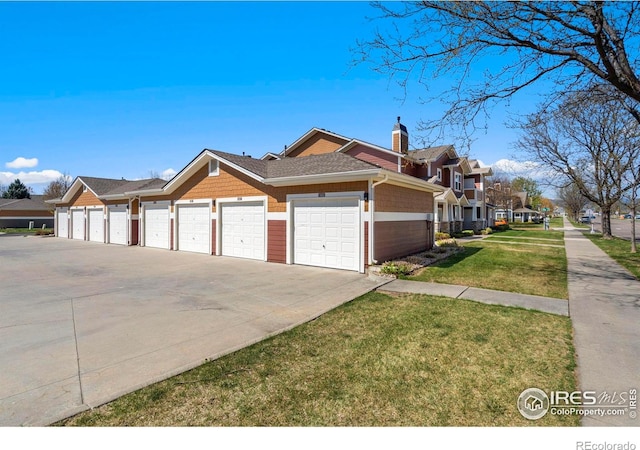 2202 Owens Ave # 102, Fort Collins, CO 80528 - view of side of property featuring a yard, a residential view, a chimney, community garages, and a shingled roof