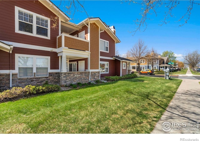 2202 Owens Ave # 102, Fort Collins, CO 80528 - view of side of property with a balcony, a chimney, a yard, and stone siding