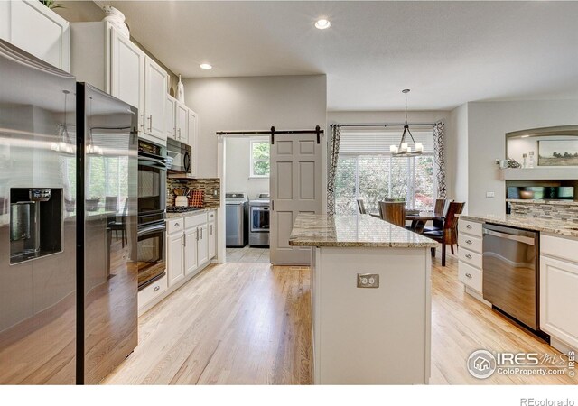 6208 Treestead Ct, Fort Collins, CO 80528 - kitchen featuring black appliances, washing machine and dryer, decorative backsplash, a center island, and recessed lighting