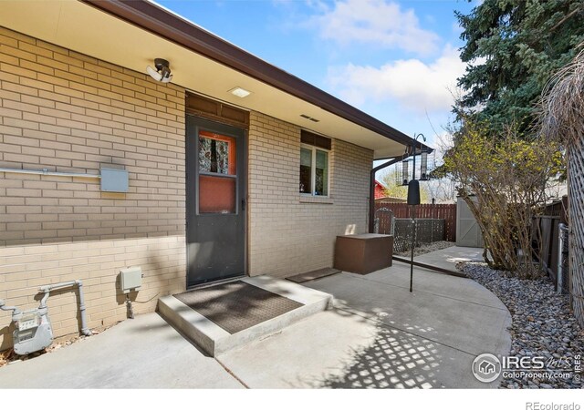 1204 Newsom St, Fort Collins, CO 80524 - view of exterior entry with brick siding and a patio area