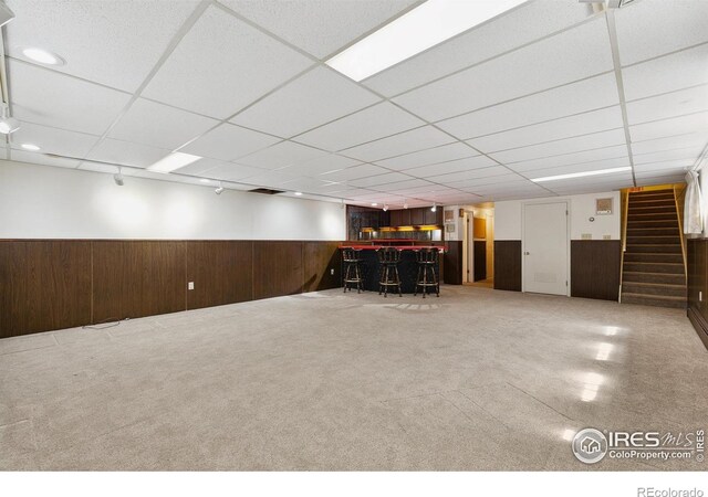 1204 Newsom St, Fort Collins, CO 80524 - finished basement with wet bar, a wainscoted wall, wood walls, stairway, and a drop ceiling