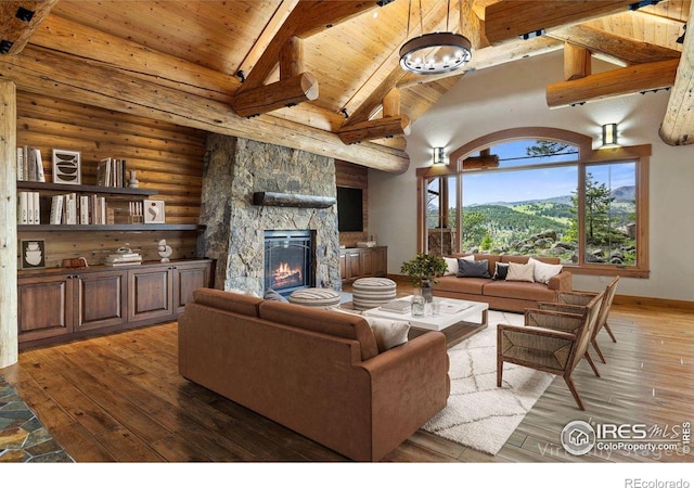 409 Wild Horse Cir, Boulder, CO 80304 - living room with a wooden ceiling with exposed beams, a stone fireplace, hardwood / wood-style floors, log walls, and high vaulted ceiling