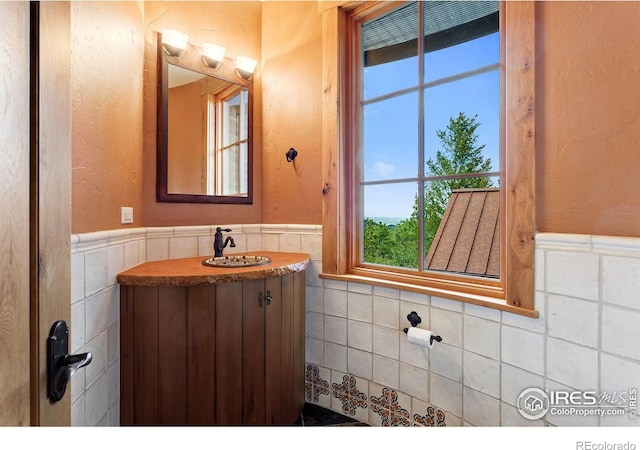 409 Wild Horse Cir, Boulder, CO 80304 - half bath featuring wainscoting, vanity, tile walls, and a textured wall