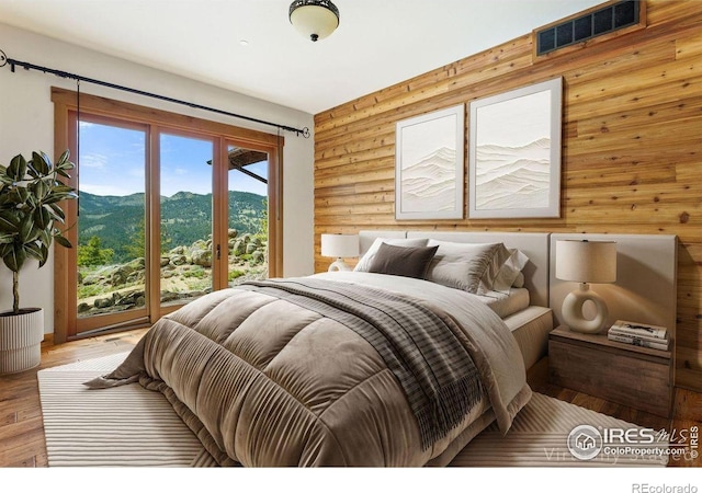 409 Wild Horse Cir, Boulder, CO 80304 - bedroom with a mountain view, access to exterior, wood finished floors, and log walls