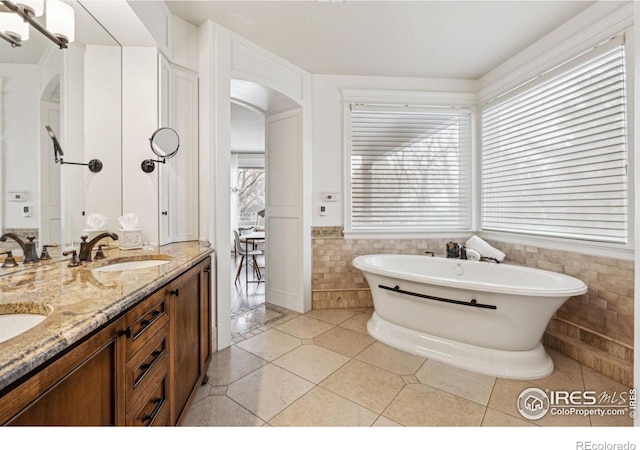 3835 Norwood Ct, Boulder, CO 80304 - full bathroom with tile walls, a freestanding bath, double vanity, a wainscoted wall, and tile patterned floors