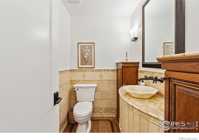 3835 Norwood Ct, Boulder, CO 80304 - bathroom featuring toilet, vanity, a wainscoted wall, and tile walls