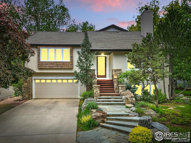 3835 Norwood Ct, Boulder, CO 80304 - view of front facade with concrete driveway, an attached garage, and a chimney