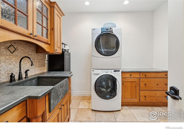 3835 Norwood Ct, Boulder, CO 80304 - washroom with estacked washer and dryer, cabinet space, baseboards, recessed lighting, and light stone finish flooring