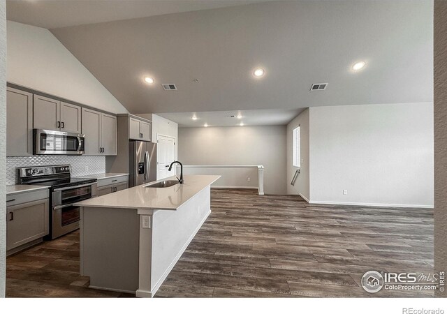 539 Vicot Way Unit C, Fort Collins, CO 80524 - kitchen featuring stainless steel appliances, gray cabinets, a center island with sink, tasteful backsplash, and dark wood-style floors