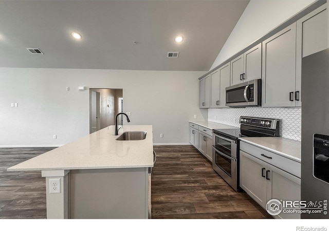 539 Vicot Way Unit C, Fort Collins, CO 80524 - kitchen featuring appliances with stainless steel finishes, gray cabinets, a center island with sink, dark wood-type flooring, and tasteful backsplash