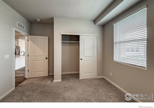 539 Vicot Way Unit C, Fort Collins, CO 80524 - unfurnished bedroom with carpet flooring, multiple windows, a closet, and stainless steel refrigerator with ice dispenser