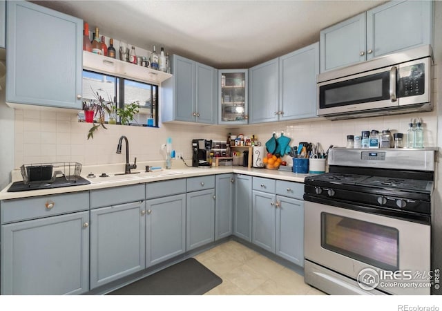 6743 King St, Denver, CO 80221 - kitchen with appliances with stainless steel finishes, a sink, backsplash, light countertops, and glass insert cabinets
