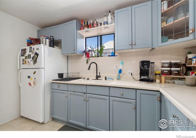 6743 King St, Denver, CO 80221 - kitchen with freestanding refrigerator, decorative backsplash, blue cabinetry, light countertops, and a sink