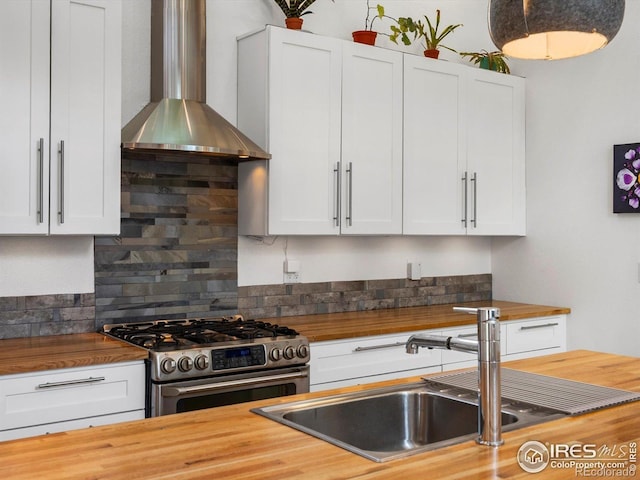 404 W Cleveland St, Lafayette, CO 80026 - kitchen featuring butcher block countertops, wall chimney range hood, stainless steel gas range, decorative backsplash, and a sink