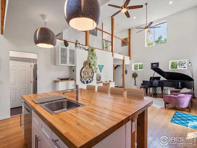 404 W Cleveland St, Lafayette, CO 80026 - kitchen featuring butcher block countertops, stacked washer and clothes dryer, a sink, a ceiling fan, and white cabinets