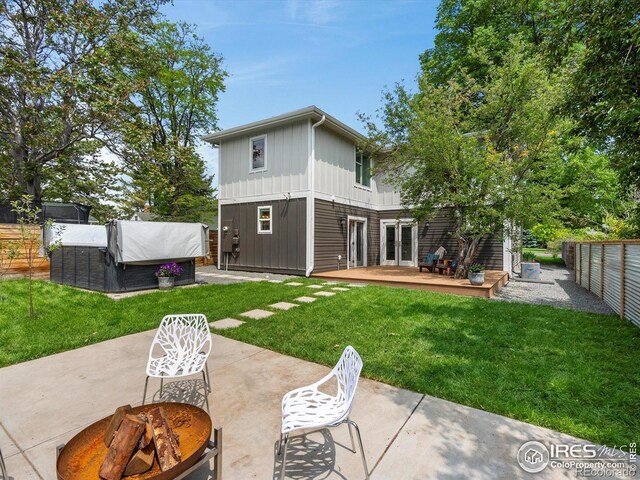 404 W Cleveland St, Lafayette, CO 80026 - rear view of property with board and batten siding, a patio area, a wooden deck, a fire pit, and a covered hot tub
