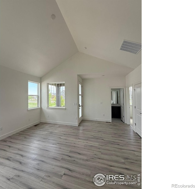 6113 Zebulon Pl, Timnath, CO 80547 - unfurnished living room with vaulted ceiling, wood finished floors, and baseboards