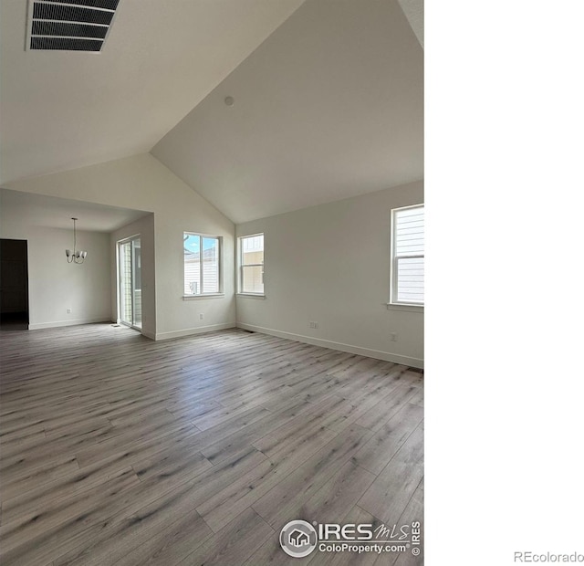6113 Zebulon Pl, Timnath, CO 80547 - empty room with a chandelier, wood finished floors, lofted ceiling, and baseboards