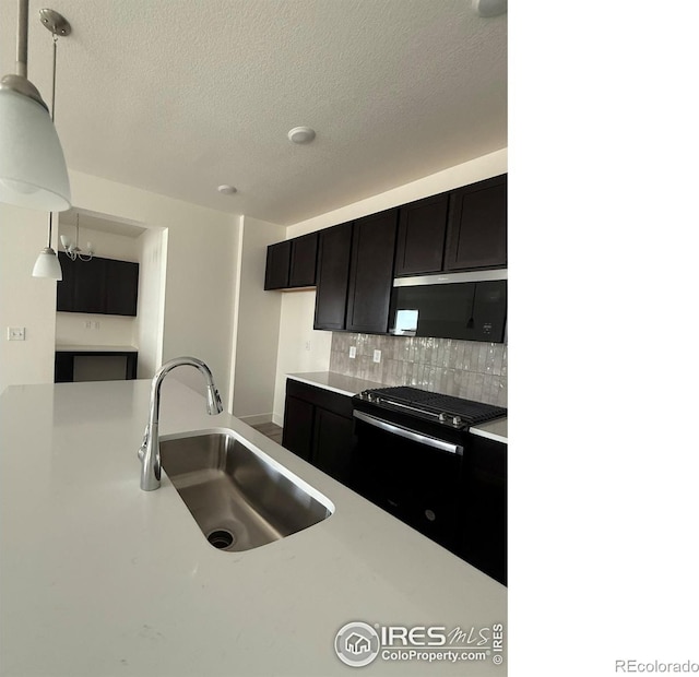 6113 Zebulon Pl, Timnath, CO 80547 - kitchen with gas stove, a sink, light countertops, decorative backsplash, and a textured ceiling