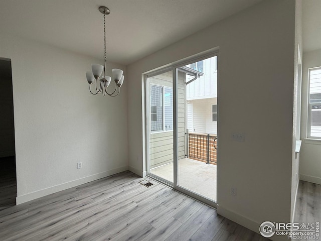 6113 Zebulon Pl, Timnath, CO 80547 - unfurnished dining area with light wood finished floors, healthy amount of natural light, a chandelier, and baseboards
