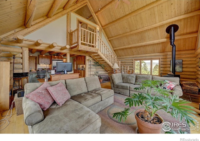 114 Jade Way, Lyons, CO 80540 - living room with rustic walls, wooden ceiling with exposed beams, high vaulted ceiling, a wood stove, and wood finished floors