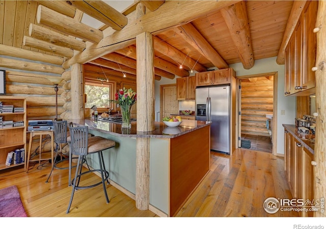 114 Jade Way, Lyons, CO 80540 - kitchen featuring stainless steel fridge, rustic walls, light wood finished floors, a peninsula, and wooden ceiling with exposed beams