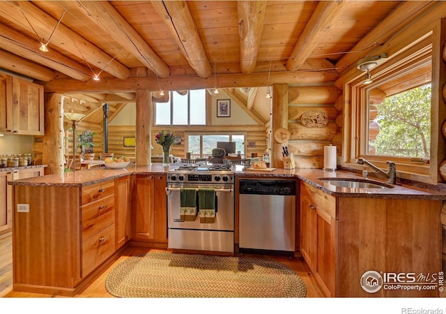114 Jade Way, Lyons, CO 80540 - kitchen featuring appliances with stainless steel finishes, a sink, log walls, light wood-type flooring, and dark stone counters