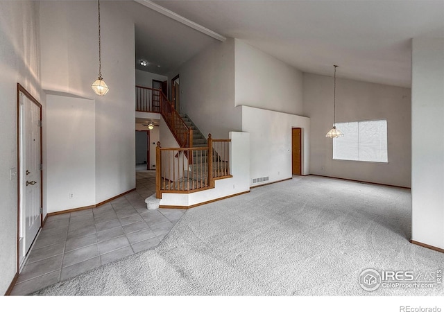 678 Mcclure Ct, Erie, CO 80516 - unfurnished living room featuring high vaulted ceiling, baseboards, stairway, and tile patterned flooring