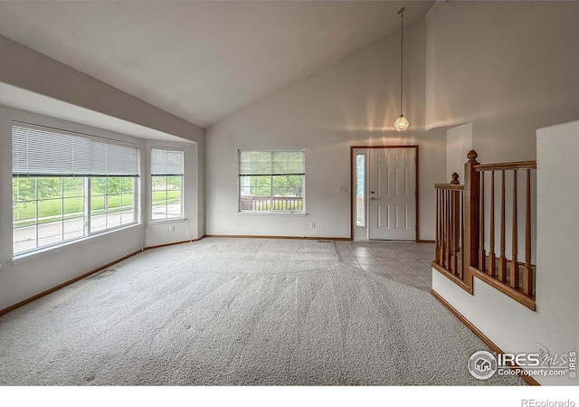 678 Mcclure Ct, Erie, CO 80516 - carpeted empty room featuring plenty of natural light, high vaulted ceiling, baseboards, and tile patterned floors