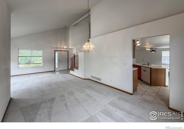 678 Mcclure Ct, Erie, CO 80516 - unfurnished dining area with baseboards, light colored carpet, high vaulted ceiling, a chandelier, and a sink
