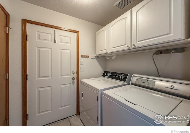 678 Mcclure Ct, Erie, CO 80516 - laundry area featuring washing machine and dryer, cabinet space, light tile patterned floors, and a textured ceiling