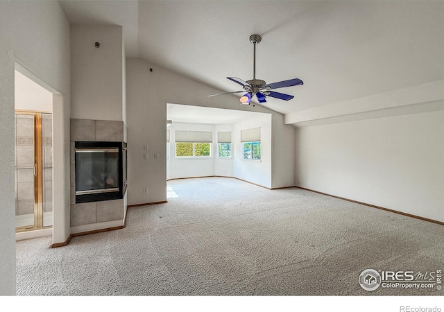 678 Mcclure Ct, Erie, CO 80516 - unfurnished living room featuring vaulted ceiling, carpet flooring, ceiling fan, a tile fireplace, and baseboards