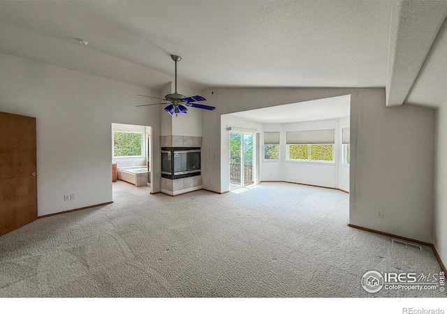 678 Mcclure Ct, Erie, CO 80516 - unfurnished living room featuring lofted ceiling, carpet, ceiling fan, baseboards, and plenty of natural light