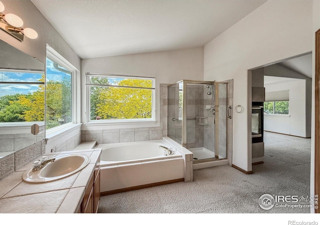 678 Mcclure Ct, Erie, CO 80516 - full bathroom with vaulted ceiling, a stall shower, a garden tub, vanity, and baseboards