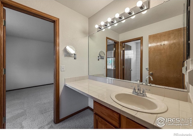 678 Mcclure Ct, Erie, CO 80516 - bathroom featuring vanity, baseboards, and a textured wall