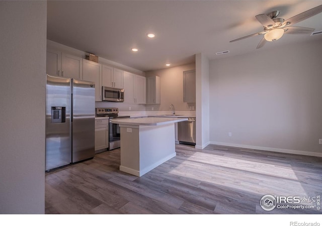710 Oregon Trl Unit B1, Ault, CO 80610 - kitchen with stainless steel appliances, a sink, wood finished floors, light countertops, and a kitchen island