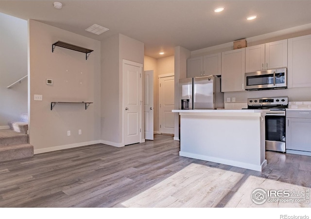 710 Oregon Trl Unit B1, Ault, CO 80610 - kitchen with stainless steel appliances, light wood-style flooring, recessed lighting, baseboards, and light countertops