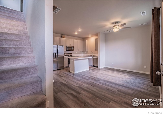 710 Oregon Trl Unit B1, Ault, CO 80610 - kitchen featuring stainless steel appliances, open floor plan, a sink, light countertops, and dark wood-style flooring