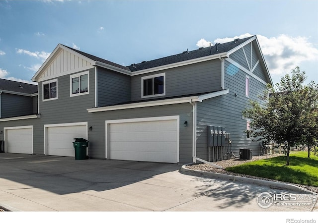 710 Oregon Trl Unit B1, Ault, CO 80610 - view of side of property with an attached garage, concrete driveway, board and batten siding, and central AC