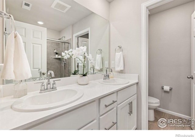 364 Fickel Farm Trl, Berthoud, CO 80513 - full bath featuring toilet, a stall shower, double vanity, and wood finished floors